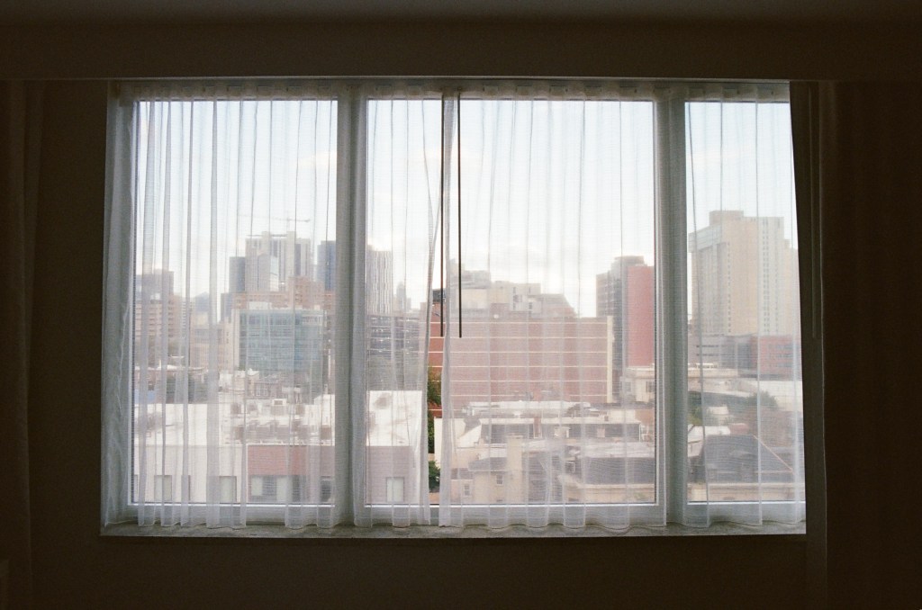 Hotel room window in Philadelphia with sheer shades.