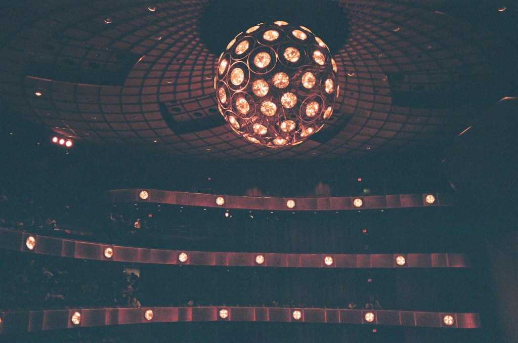 A dark photo of the interior of the David Koch theater at Lincoln Center